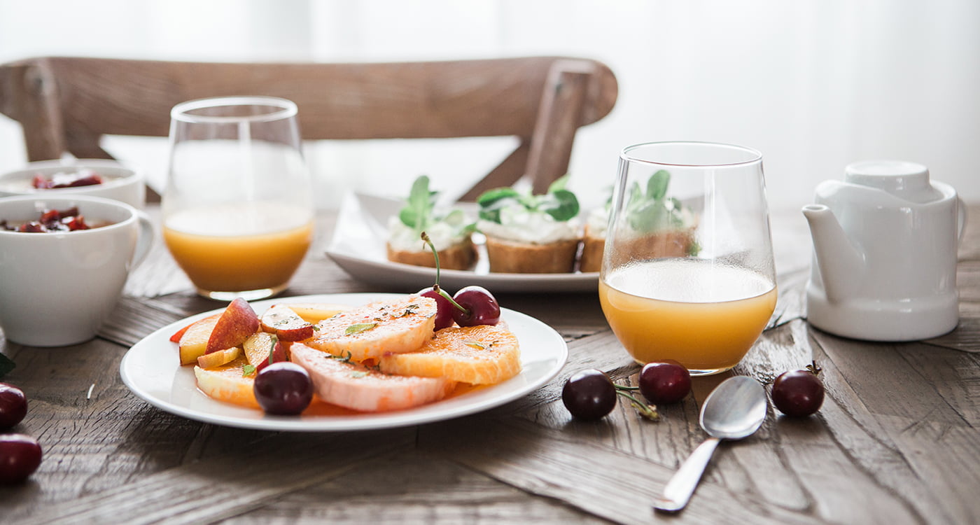 plate a fruit and teo glasses of juice